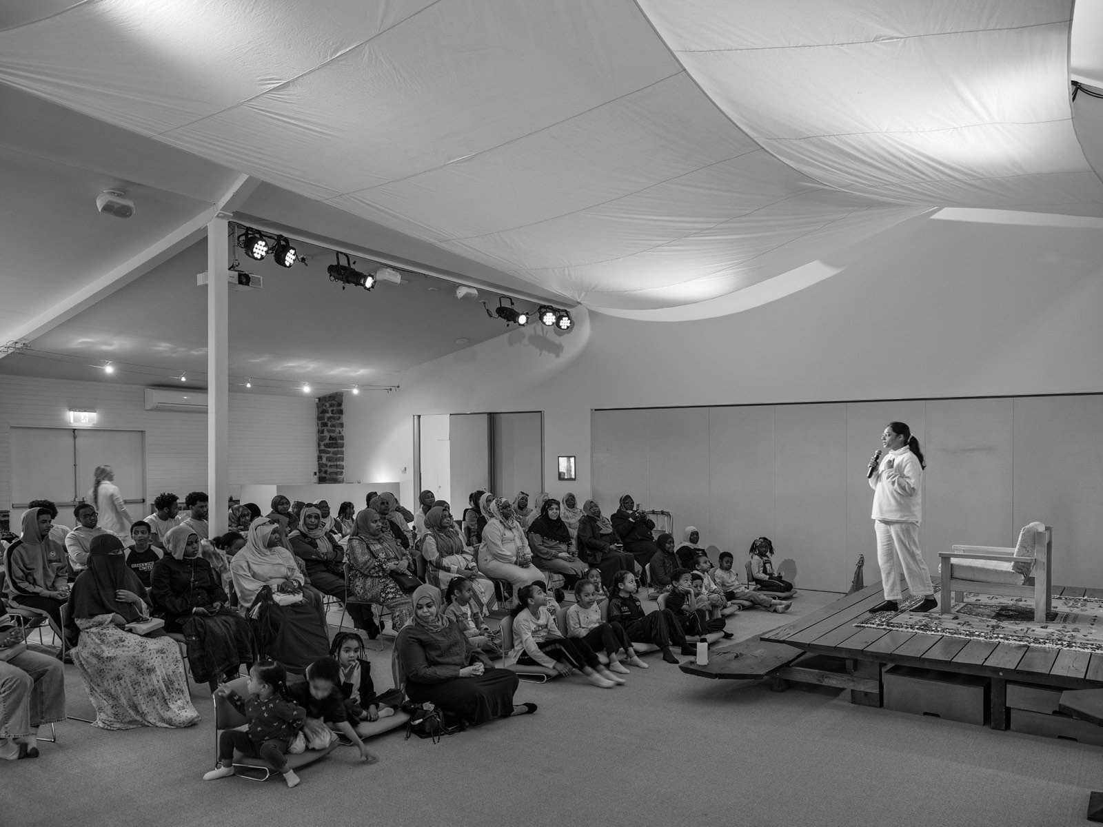 Smriti Budhia speaking to a seated group in a hall at a retreat centre in New South Wales