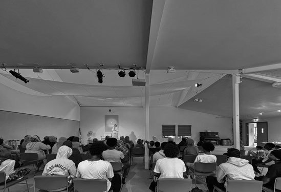 Smriti Budhia speaking to a seated group in a retreat-centre hall