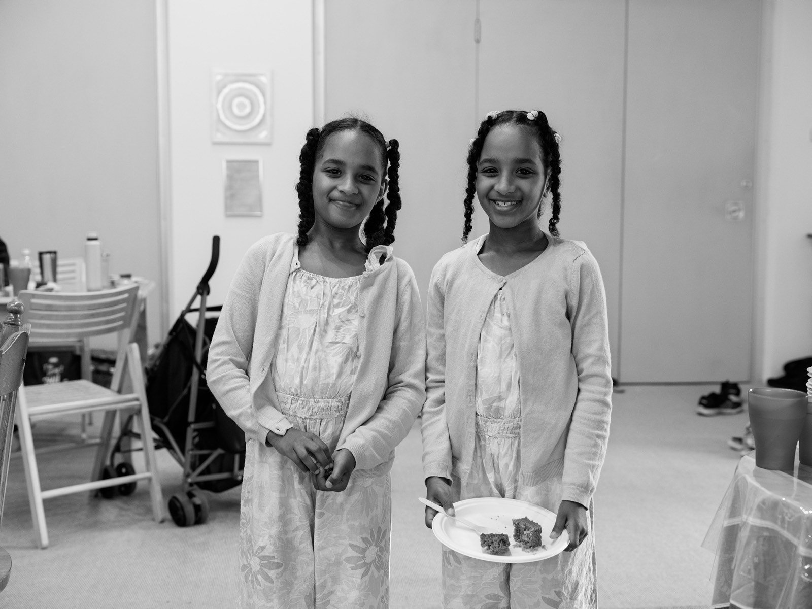 Two young sisters in matching dresses smiling for the camera