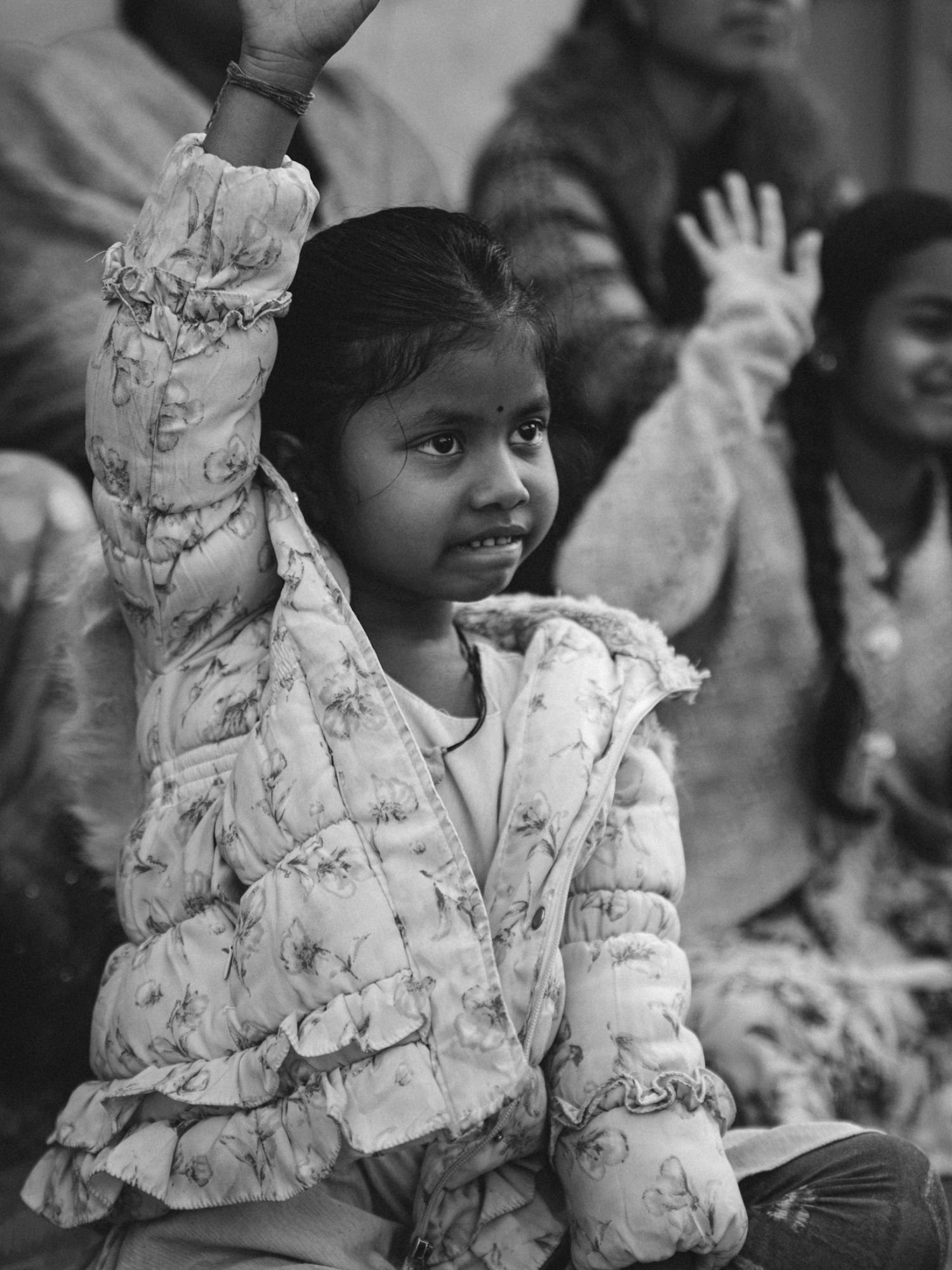 A girl raises her hand during an outdoor class
